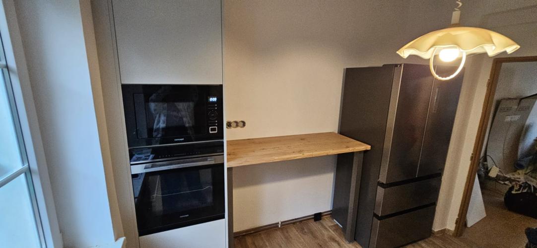 Vysoký blok se spotřebiči v čistém souladu s barovým pultem.